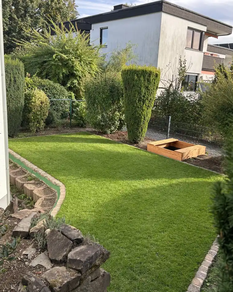 Derselbe Garten nach der Neuanlage mit Natursteineinfassung und Rollrasen